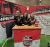 Drei Spielerinnen von Schulte Könnerschaft am Informationsstand mit rot-schwarzen Vereinstrikots bei einer Sportveranstaltung