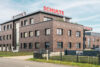 Moderner Firmensitz der Schulte-Gruppe in Klinkeroptik mit rotem Schriftzug und Slogan "Wo wir sind, ist vorne!